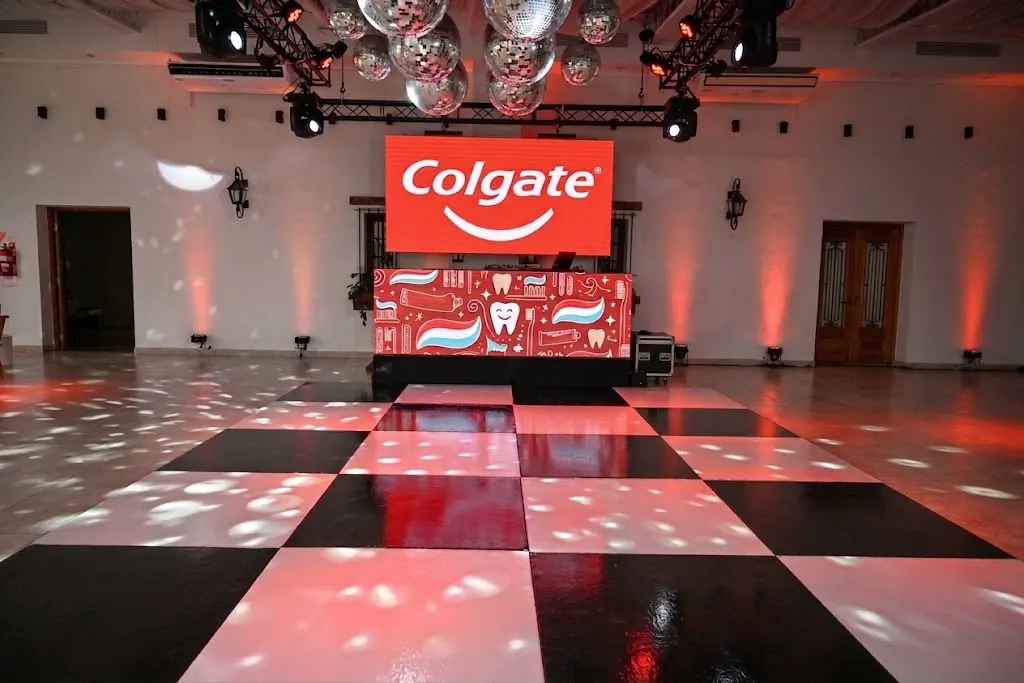 Pantalla con el logo de Colgate en el salón preparado para un evento corporativo