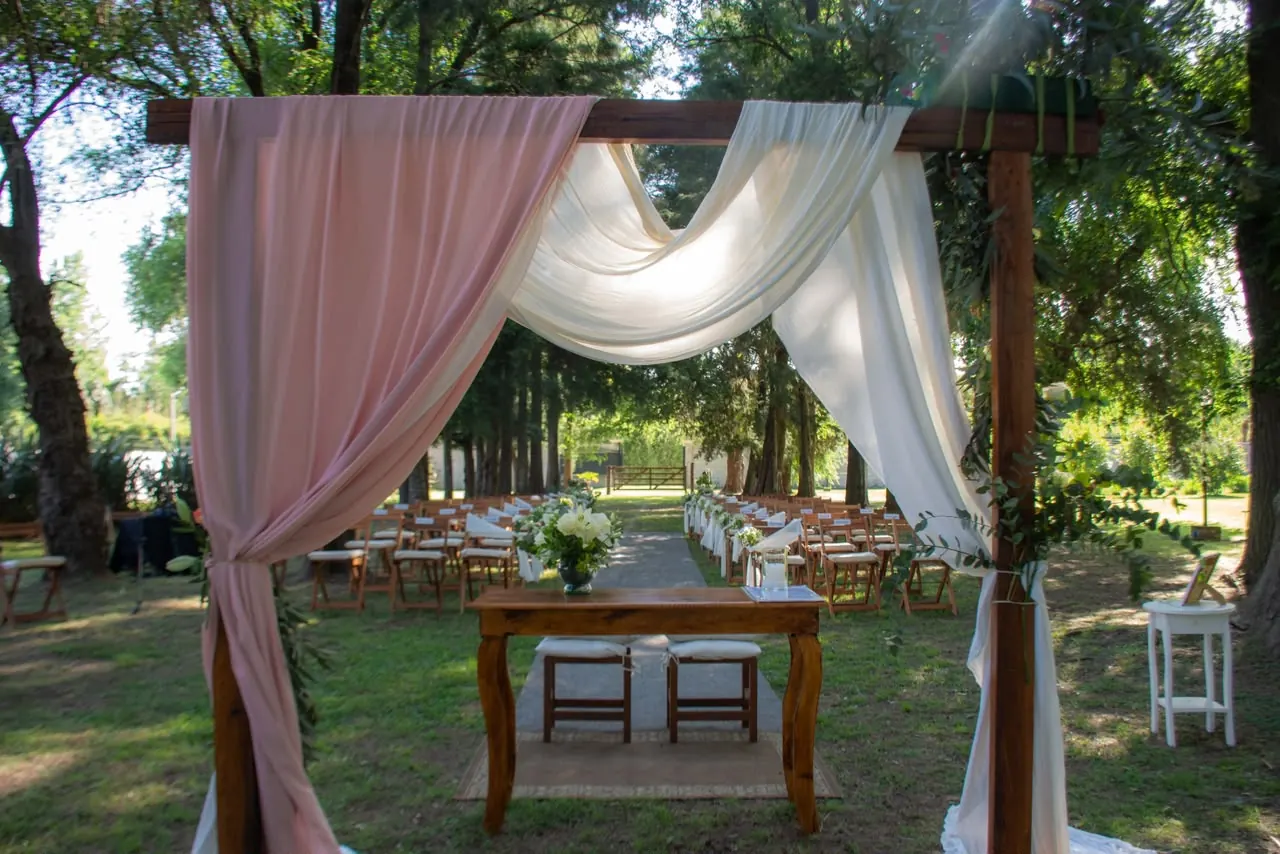 Altar de ceremonia con telas blancas y rosadas en el parque de Azahares de Escobar